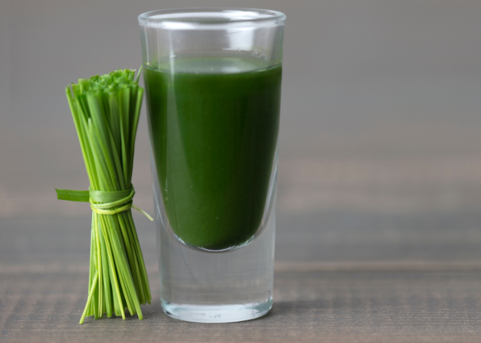 a bundle of wheatgrass and a glass of wheatgrass smoothie