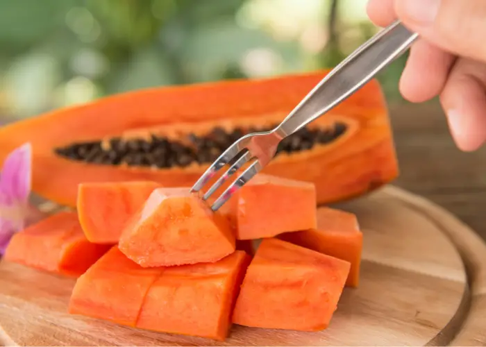 a person eating a slice of ripe papaya