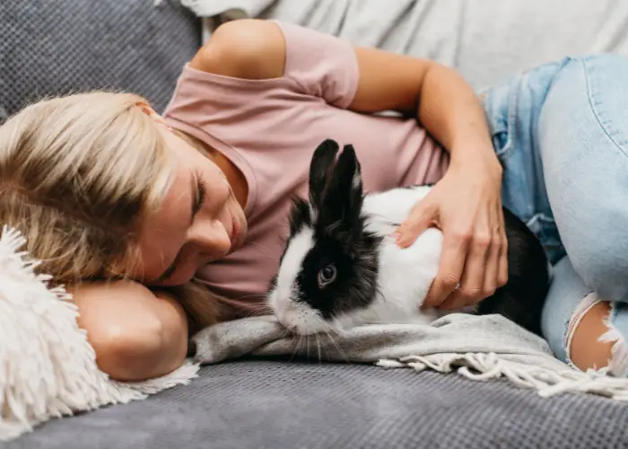 a lady petting her pet rabbit